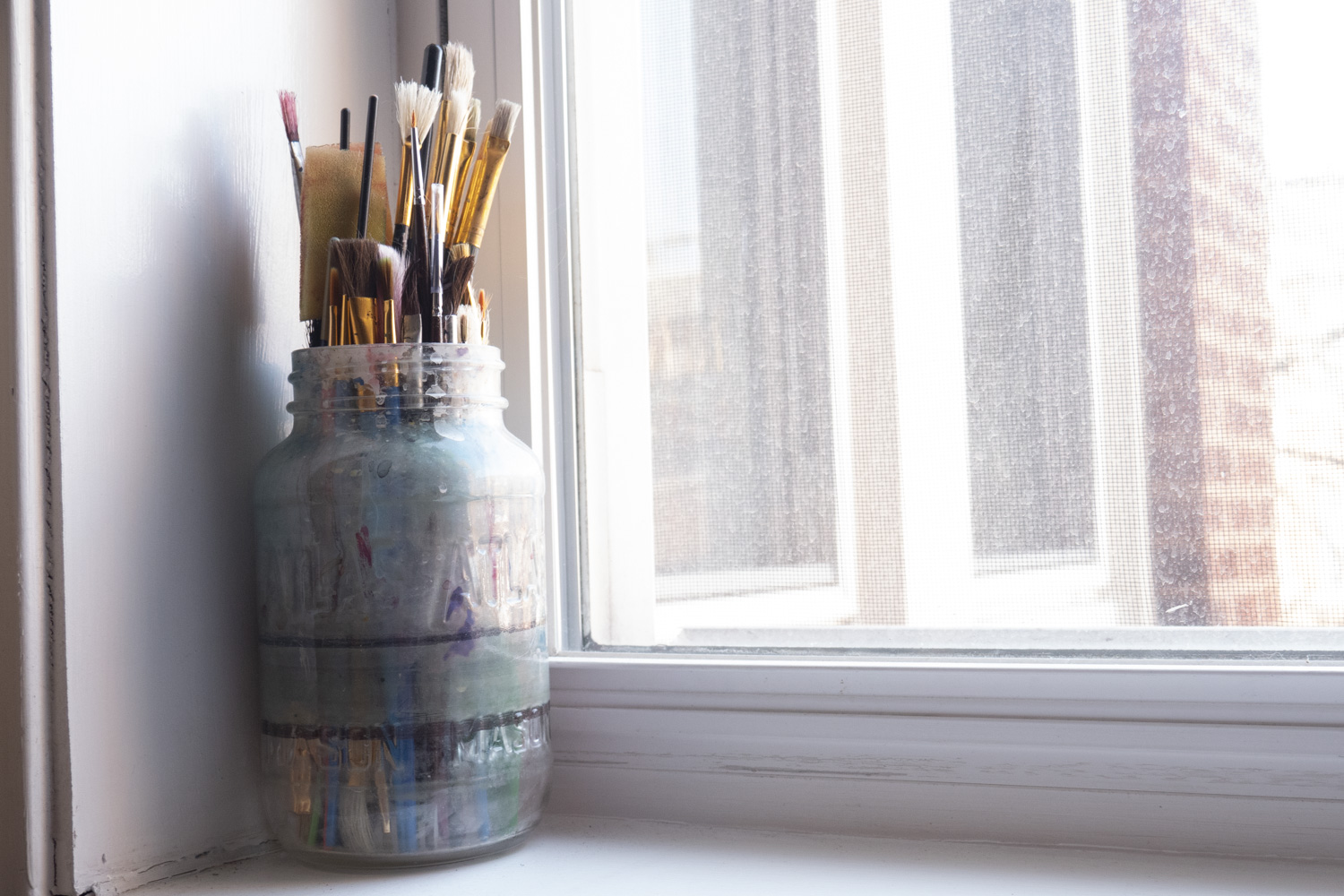 paint brushes in a window